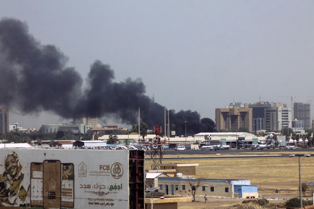 Humo brota sobre los edificios en las cercanías del aeropuerto de Jartum. | AFP
