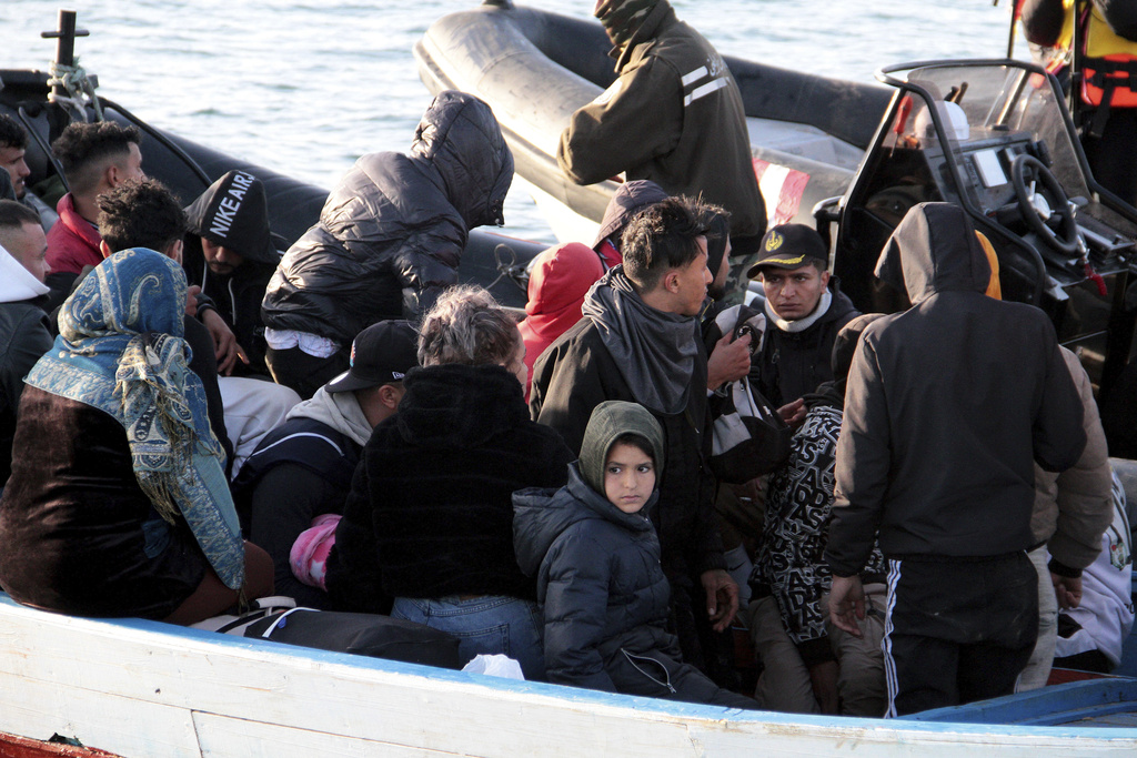 Los grupos de personas sacadas del agua durante varias salidas de pequeñas embarcaciones son reunidas en un barco nodriza de la Guardia Nacional | AP