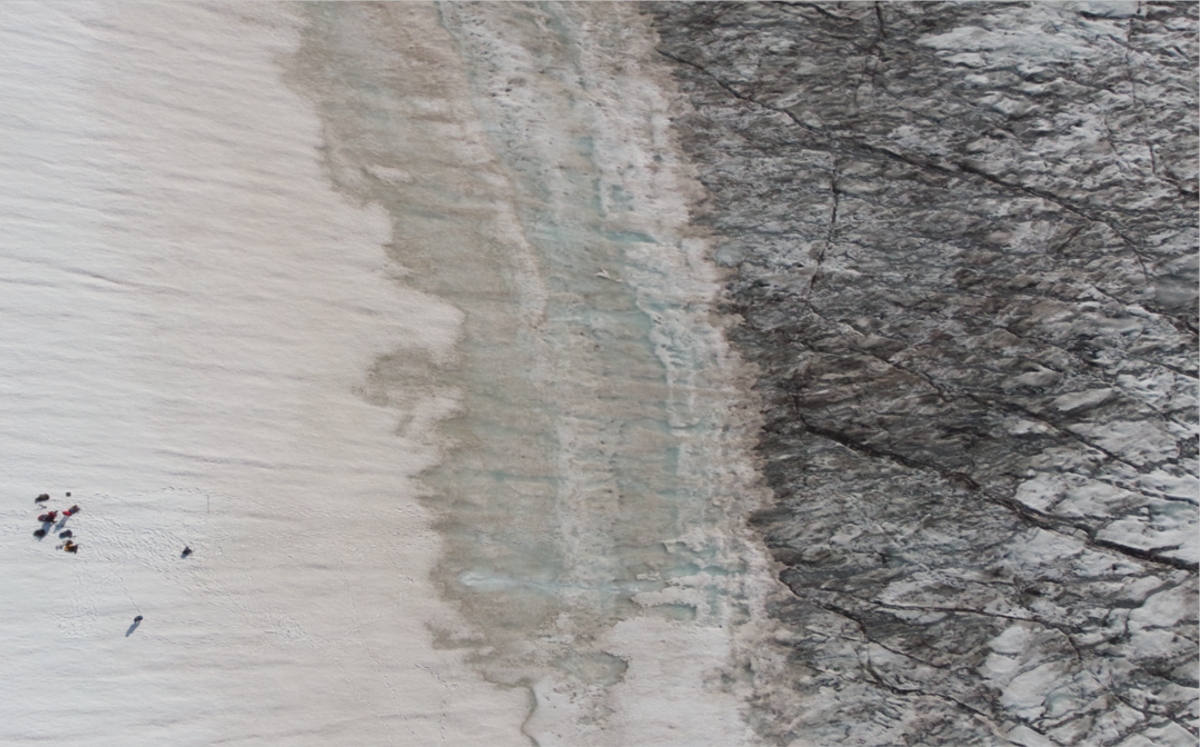 investigadores, ubicados en el lado blanco, tomaron una foto con un dron sobre el lado negro del hielo. | Universidad de Aarhus