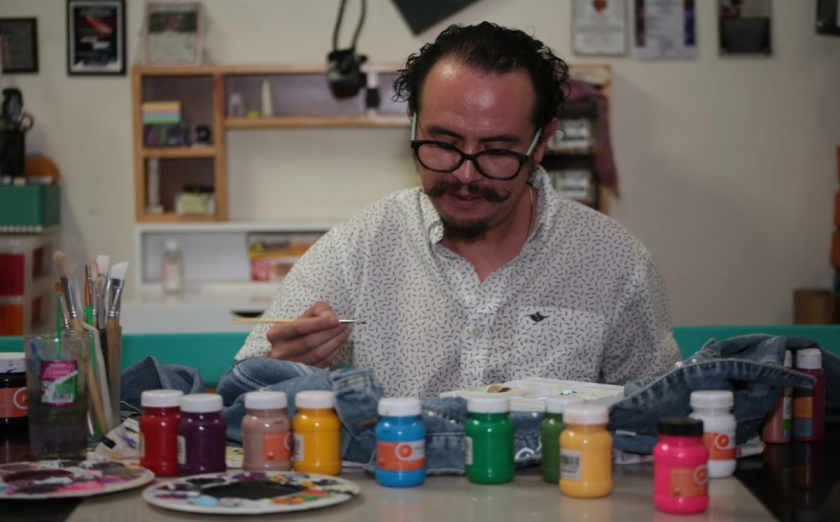 Giovanni Agustín Santa Cruz González en el taller donde personaliza los tenis y otras prendas para recaudar fondos (Tania Contreras)