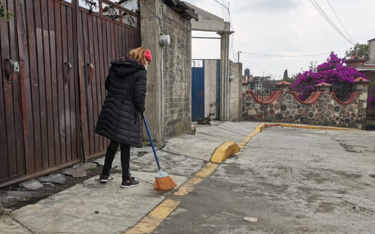 Persona barre la ceniza que arroja el volcán Popocatépetl en Amecameca (Zuleyma García)