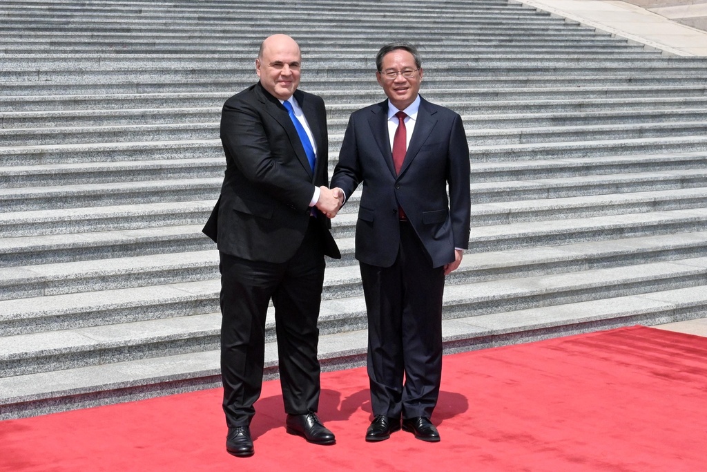 El primer ministro ruso, Mikhail Mishustin ,  y el primer ministro chino, Li Qiang, asisten a una ceremonia de bienvenida en Beijing | AP