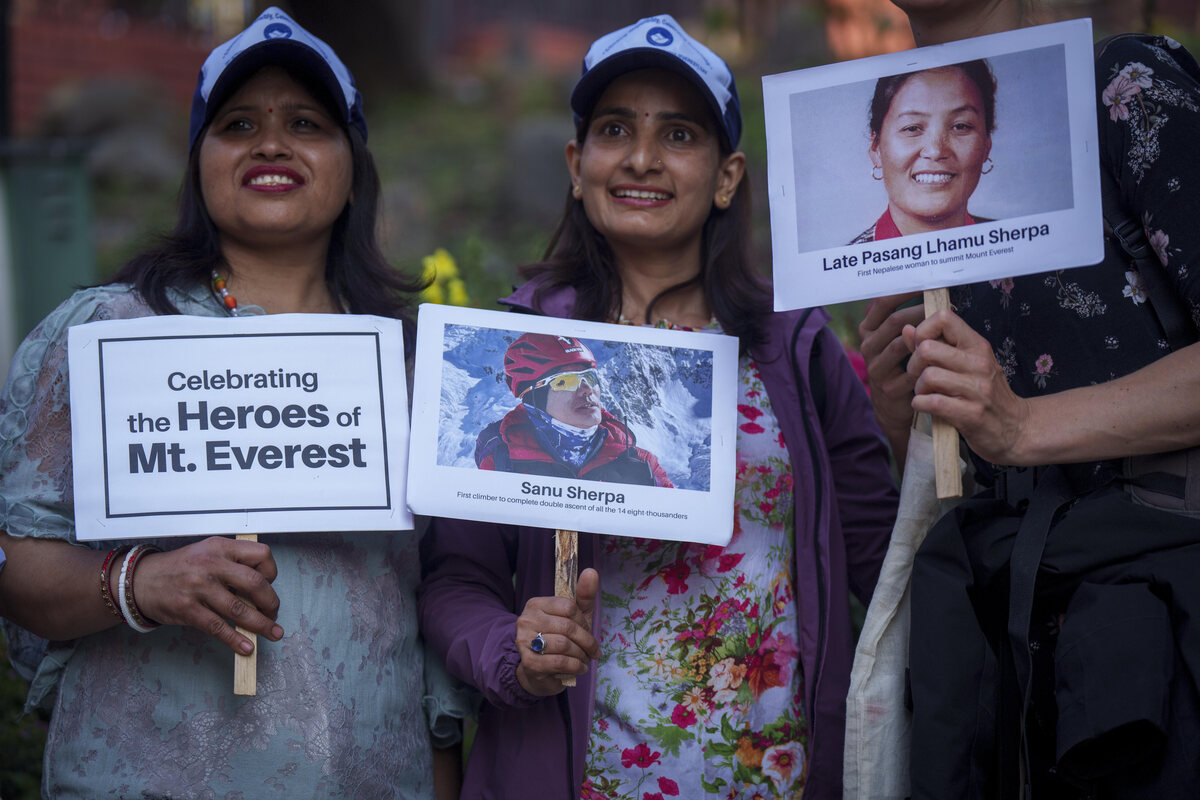 Tres mujeres sostienen carteles y fotos en homenaje a montañeros con récords | AP