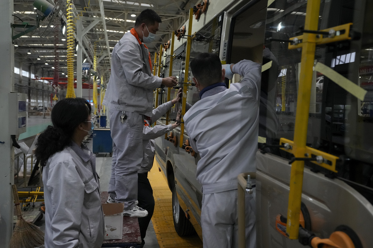 Trabajadores instalan cristales en un minibús