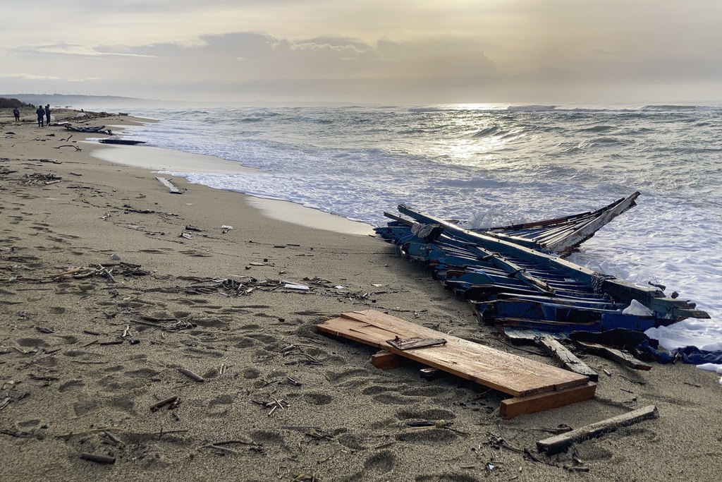 Restos de un barco naufragado arrastrado por las olas hasta una playa cerca de Cutro | AP