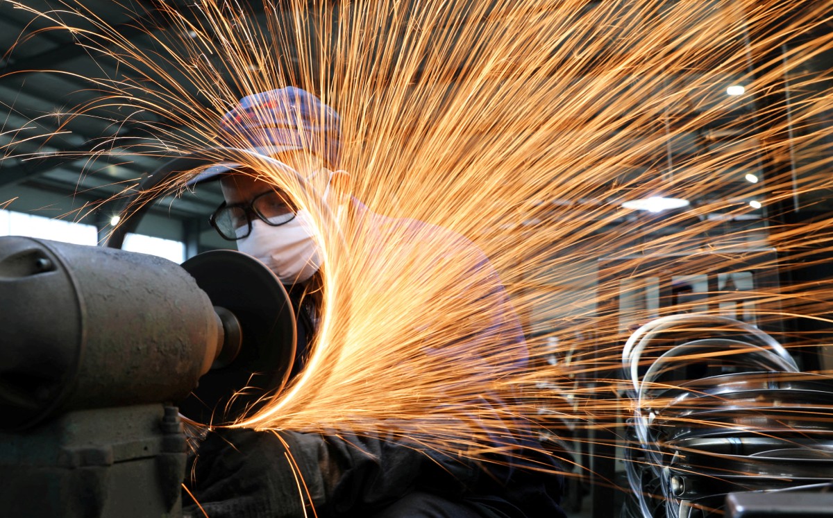 Trabajador con mascarillaen una línea de producción que fabrica llantas de acero para bicicletas en una fábrica, en Hangzhou, China. Foto: (Reuters)