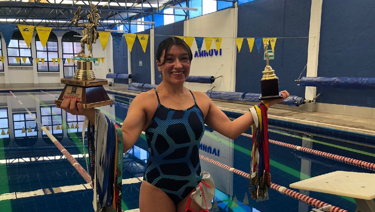Sharon Román en piscina con sus diferentes medallas y trofeos que ha ganado
