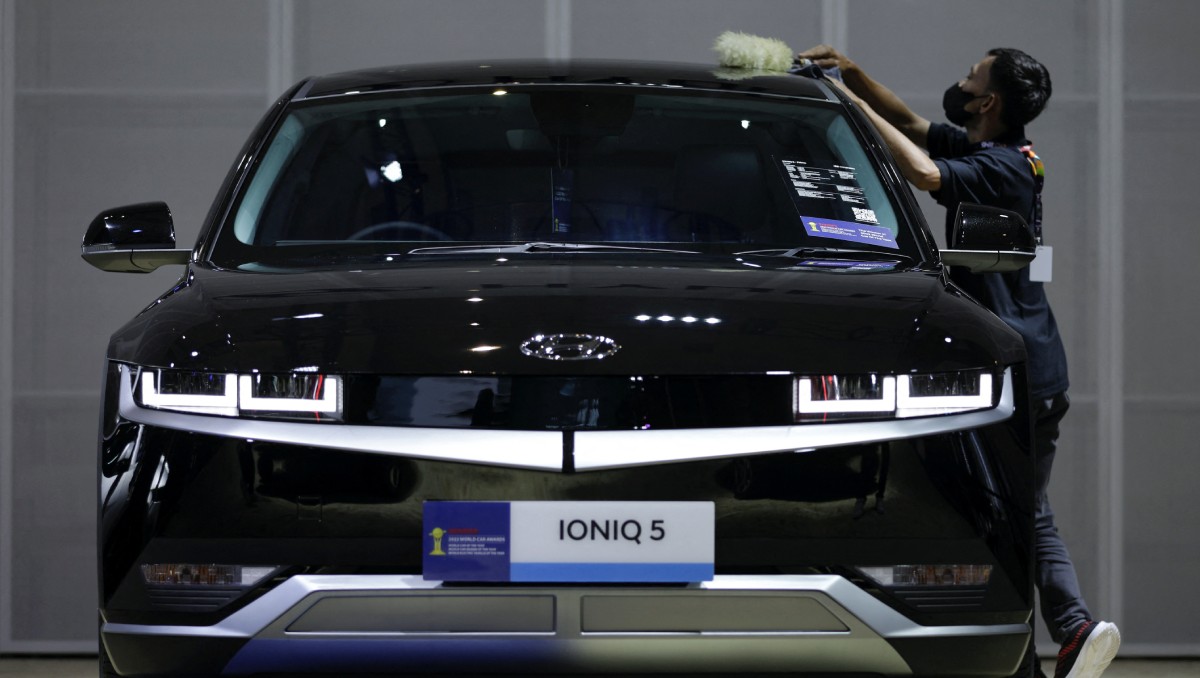 Trabajador limpia un coche eléctrico Hyundai IONIQ 5 en el Salón Internacional del Automóvil de Indonesia. Febrero de 2023. Foto: (Reuters)