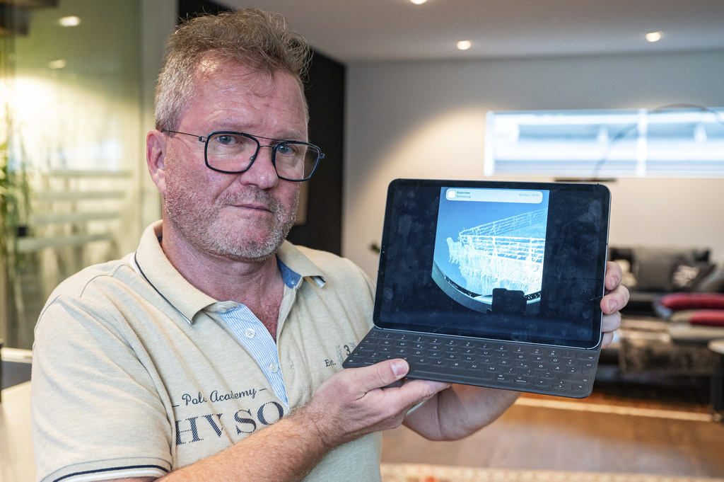 Arthur Loibl, uno de los primeros clientes de la empresa de sumergibles Oceangate, sostiene una foto del Titanic en Straubing | AP