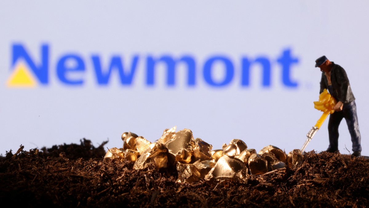 Figura de juguete e imitación de oro se ven delante del logotipo de Newmont. Noviembre de 2021.Foto: (Reuters)