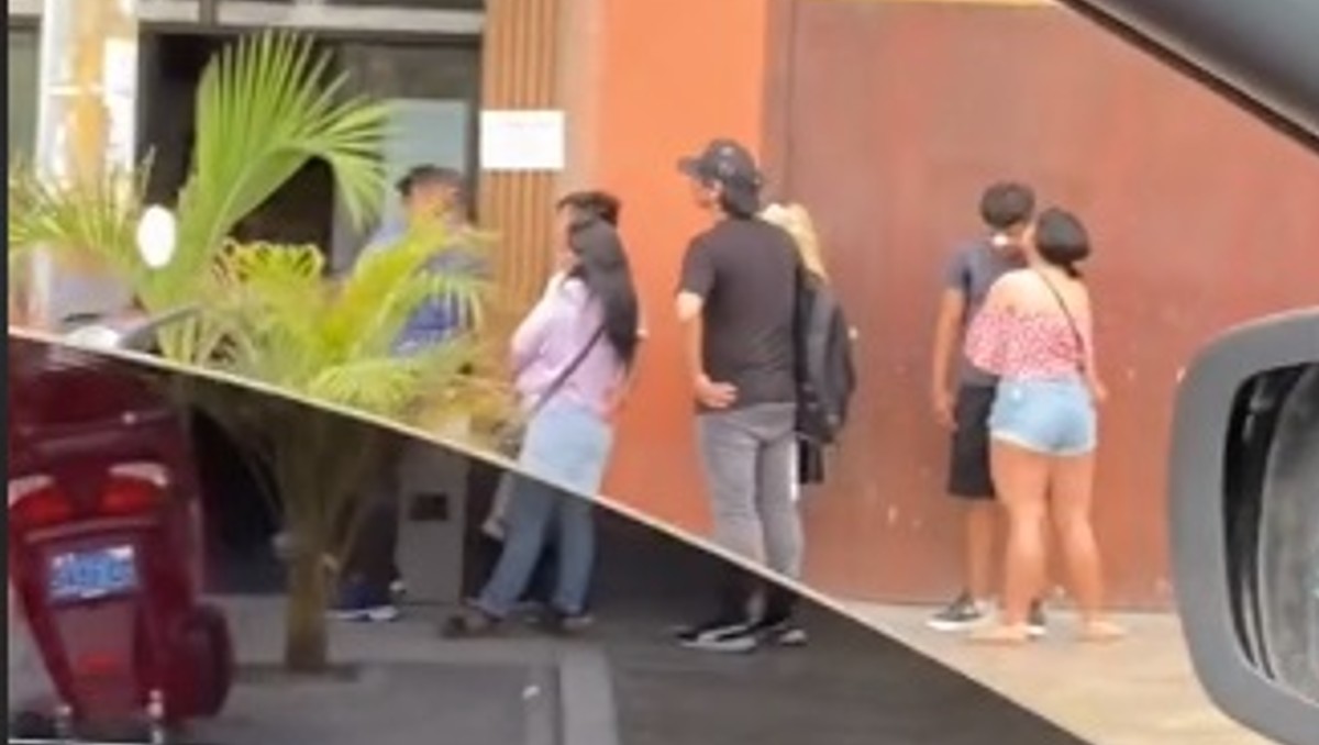 La mujer grabó a los clientes esperando por entrar | Captura