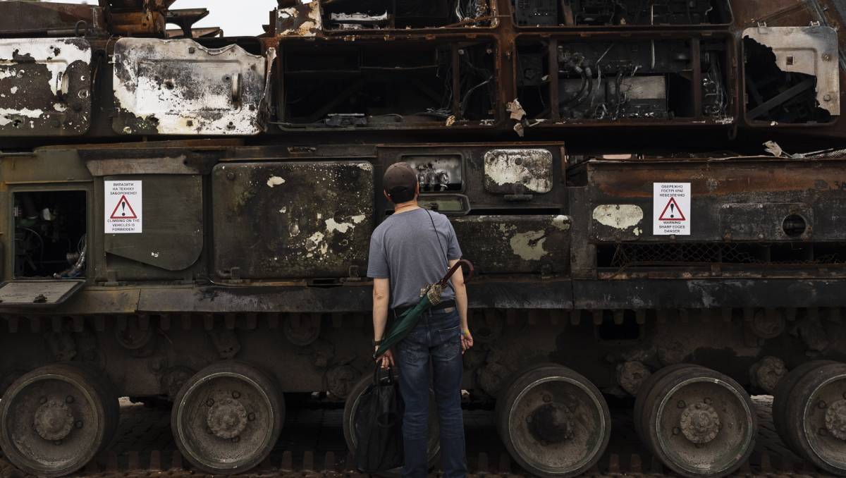 Un hombre mira un tanque destruido en Ucrania. (AP).