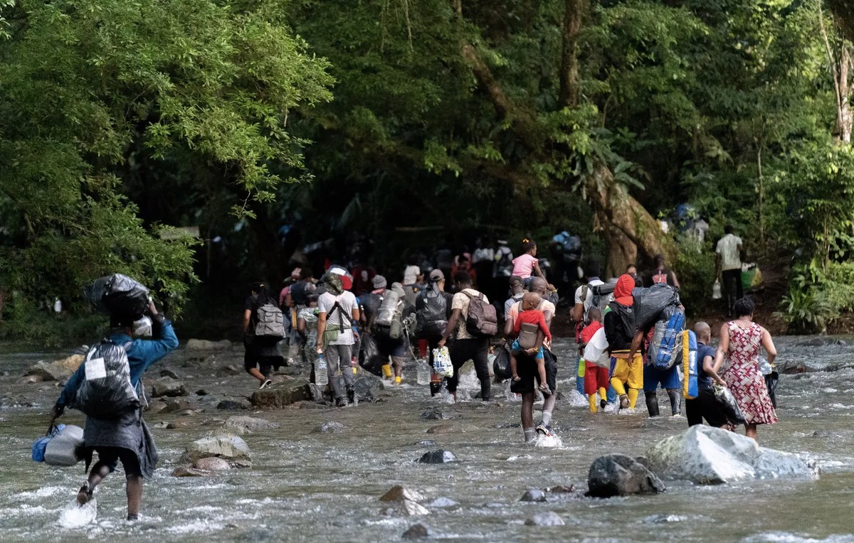 Migrantes atravesando río en la selva del Darien (Reuters)