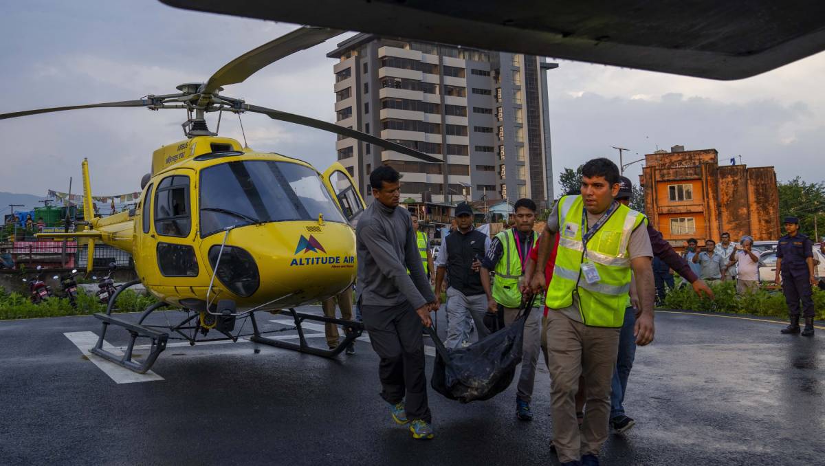 Rescatistas llevan los cuerpos a la capital de Nepal. (AP).