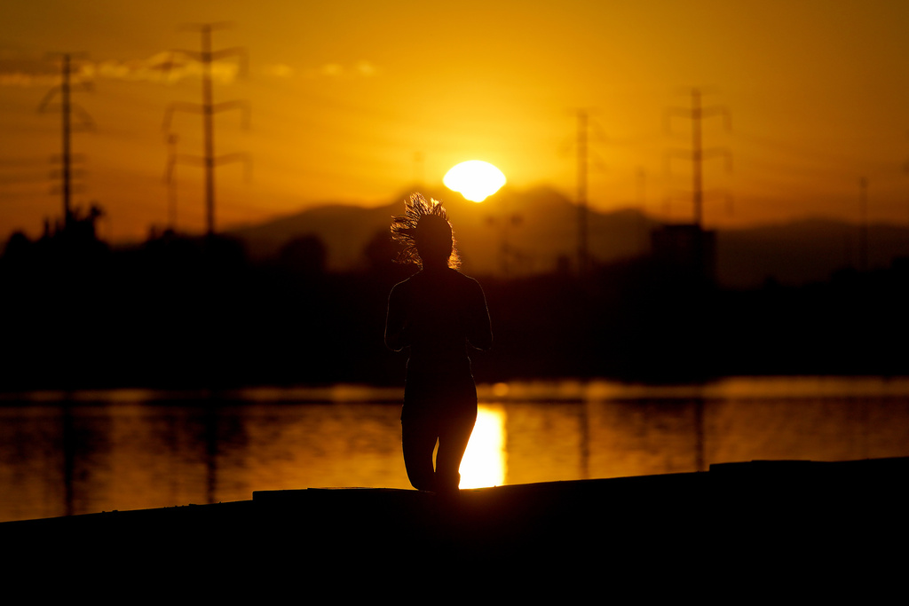 Una deportista corre al lado del lago Tempe Town al amanecer | AP