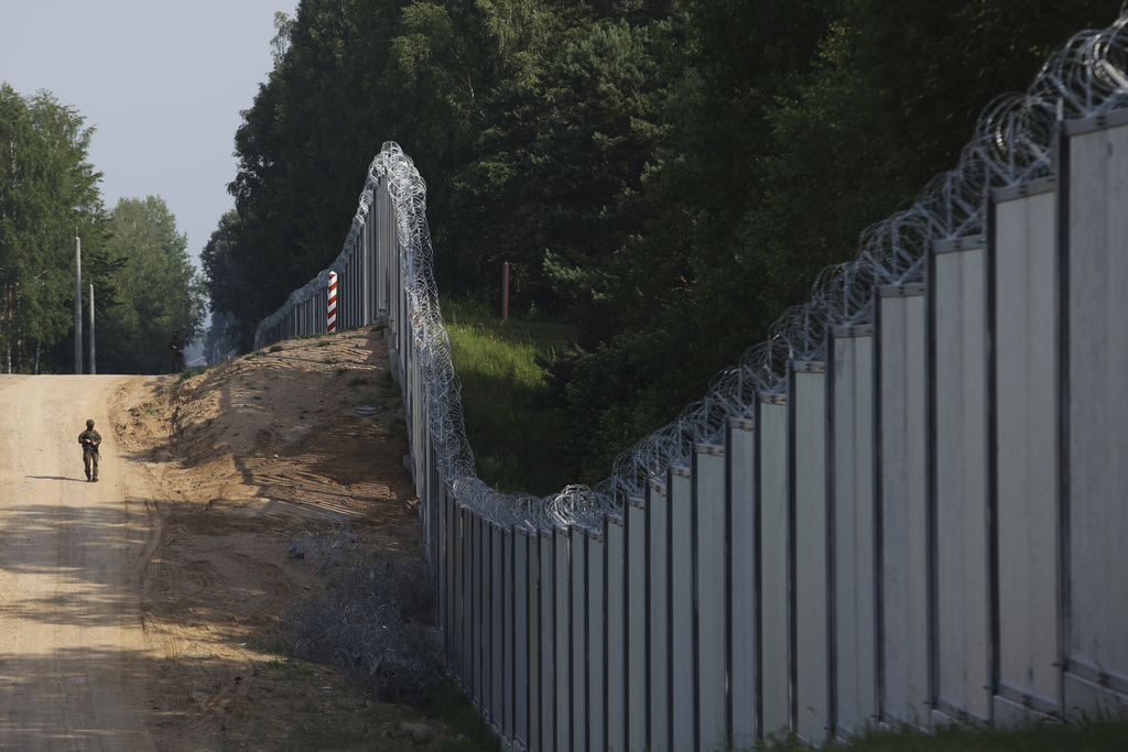 Guarda fronterizo polaco patrulla por las inmediaciones de una cerca de metal en la frontera entre Polonia y Bielorrusia | AP