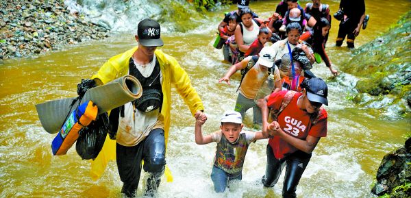 Migrantes cruzan un río en Colombia durante su viaje hacia la frontera con Estados Unidos. ADRI SALIDO/REUTERS