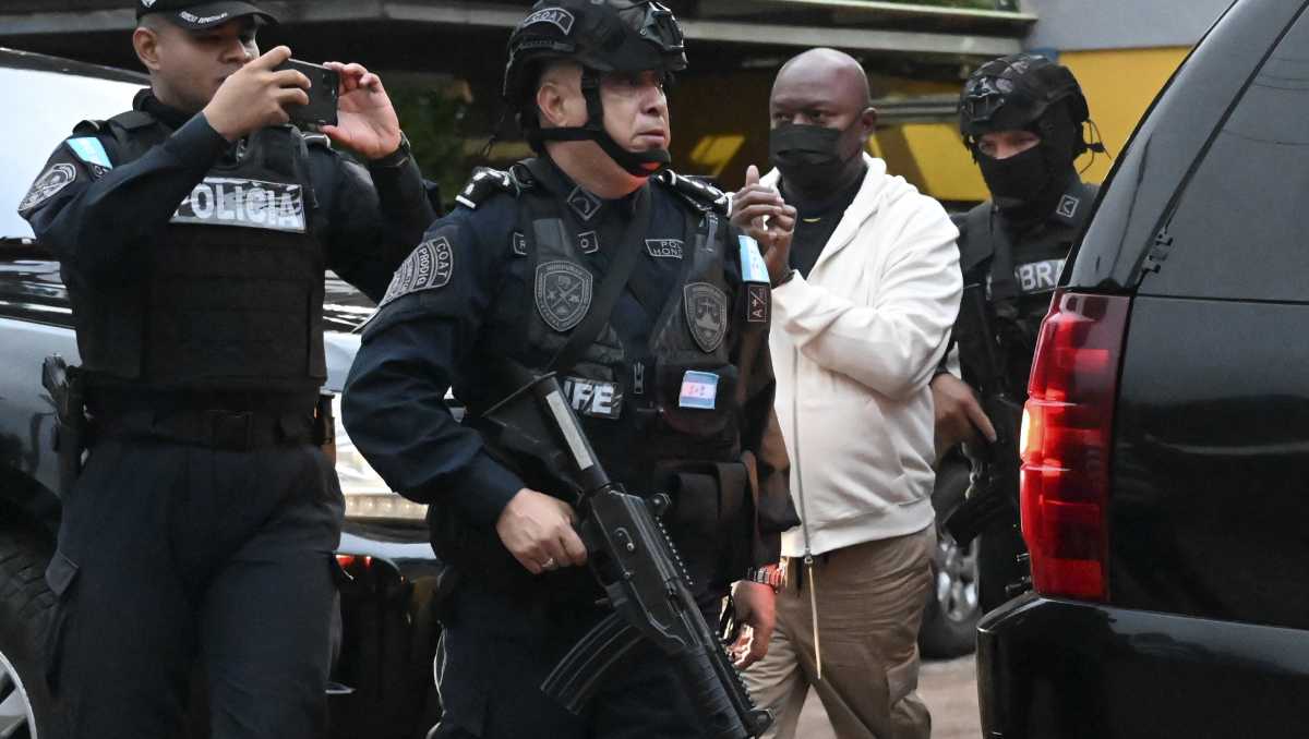 Bajo un fuerte dispositivo de seguridad, la policía hondureña trasladó al líder criminal a un avión del gobierno. | AFP