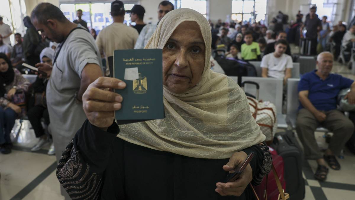 Una mujer palestina muestra su pasaporte para entrar en Egipto | AFP