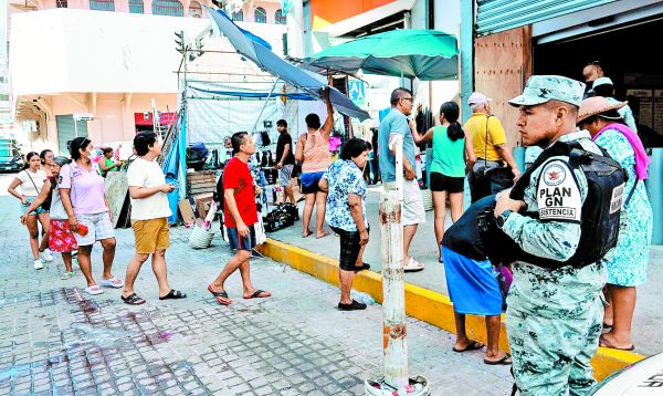 Arriba, vecinos acuden a una tienda de autoservicio vigilada; abajo, daños en las calles de la ciudad turística. ARACELI LÓPEZ