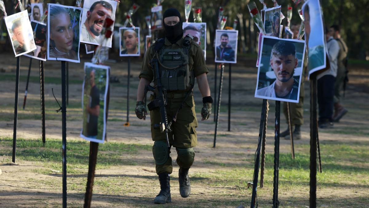 Un soldado israelí camina entre las fotos de rehenes de Hamás | AFP