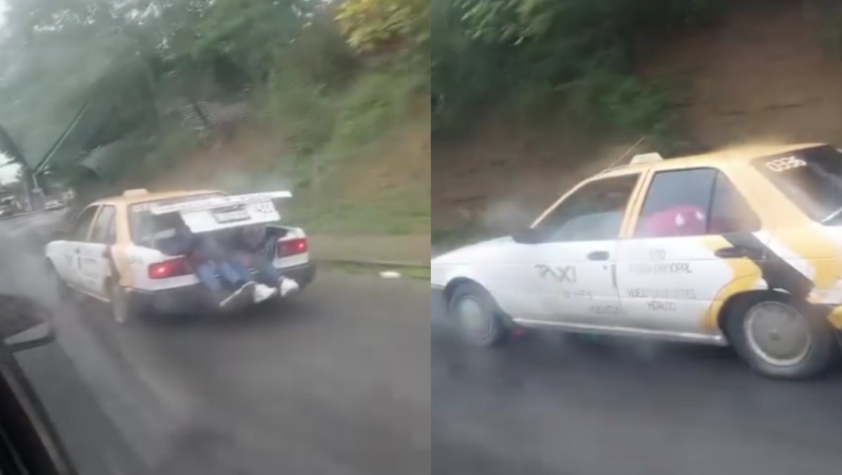 Taxi viaja a con dos pasajeros en la cajuela.
