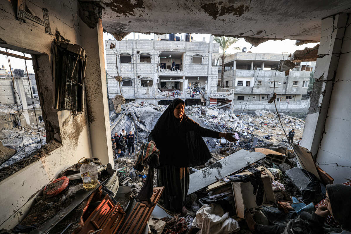 Mujer camina entre escombros de un edificio bombardeado en Palestina. | Foto: AFP