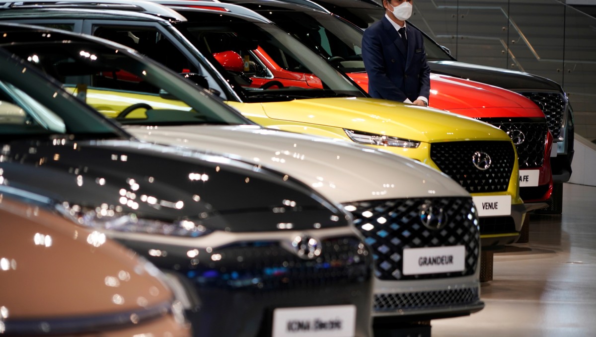 Empleado con mascarilla para evitar contraer covid-19 espera junto a un vehículo de Hyundai Motor. Abril de 2020. Foto: (Reuters)