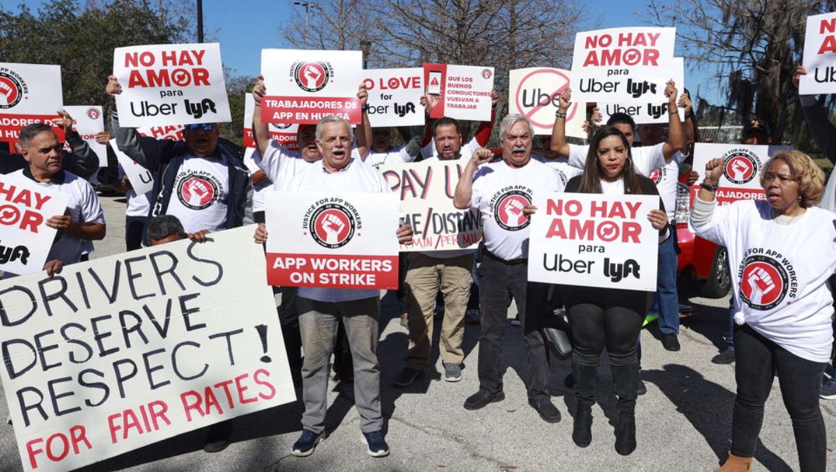 Conductores de servicios de transporte como Uber y Lyft protestan cerca del Aeropuerto Internacional de Orlando, en Orlando. Foto: (AP)
