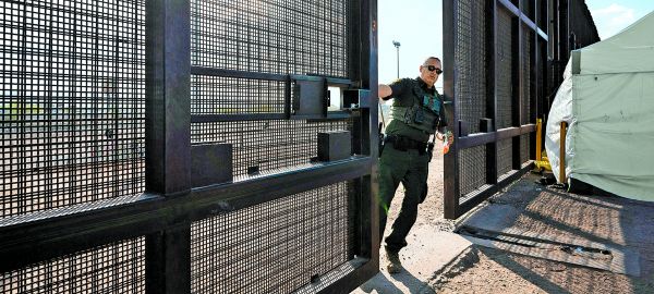 Agente de la Patrulla Fronteriza cierra la puerta del muro ubicado en El Paso y Ciudad Juárez. Reuters