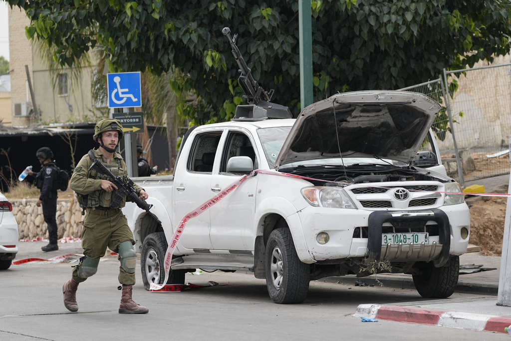 Un soldado israelí pasa junto a una camioneta utilizada por milicianos palestinos en Sderot, Israel | AP