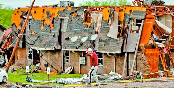 Un hombre pasa junto a un edificio dañado por un tornado este domingo en Oklahoma. REUTERS