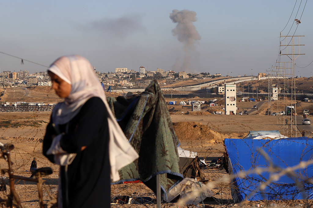 Una nube de humo señala el lugar donde se produjo un ataque aéreo israelí contra edificios cerca del muro que separa Egipto y Rafah