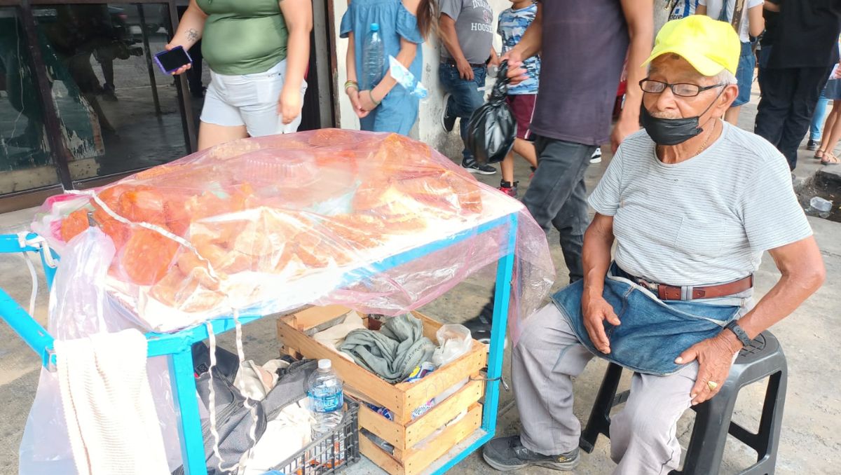 El adulto mayor aprovecha un espacio con sombra para seguir ofreciendo sus productos. Israel Santacruz