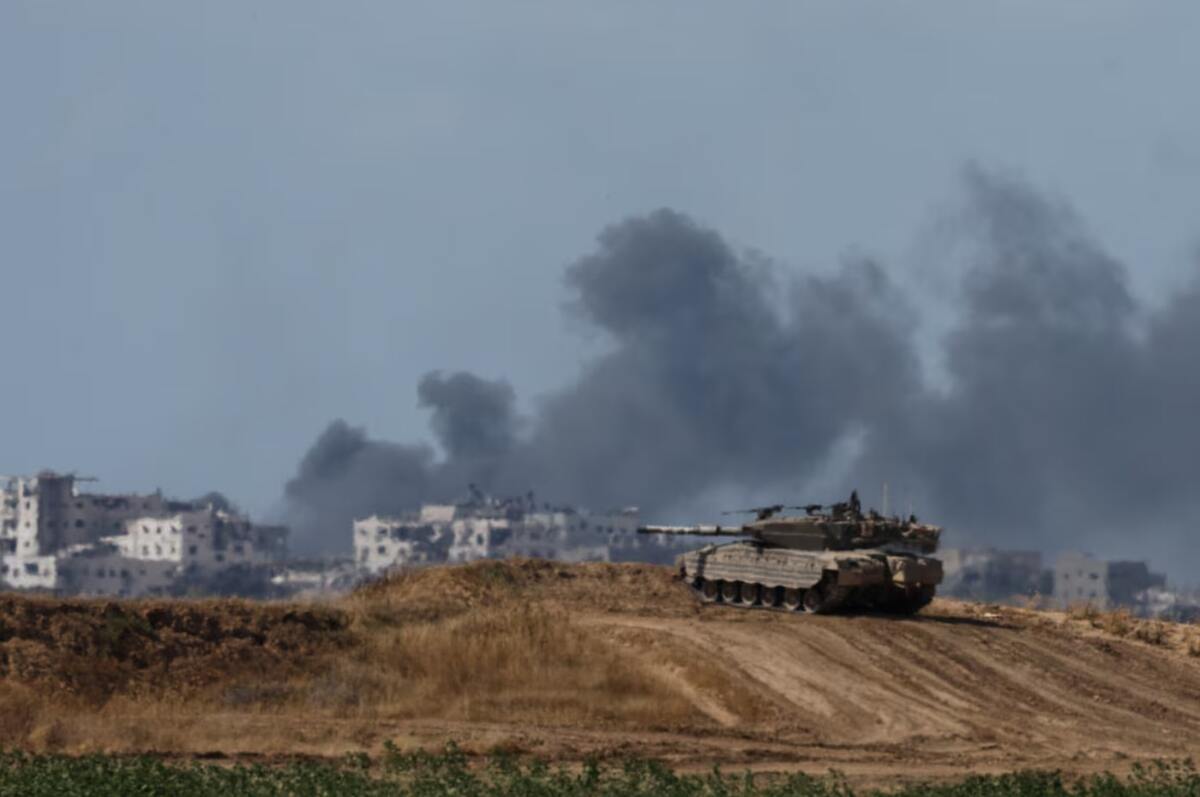 Un tanque israelí mantiene una posición mientras el humo se eleva en Gaza, cerca de la frontera entre Israel y Gaza. 13 de mayo. REUTERS/Amir Cohen