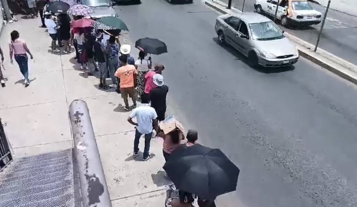 Con cartones y sombrillas, los habitantes de Huejutla hacen frente al intenso sol mientras esperan para votar