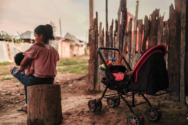 Madre adolescente sentada con su hijo en Iquitos (Perú) | Foto: EFE