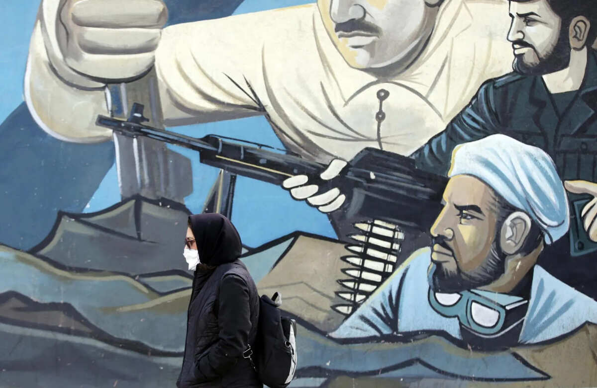 Una mujer iraní pasa junto a un mural de soldados de la guardia revolucionaria iraní en una calle de Teherán | Foto: EFE