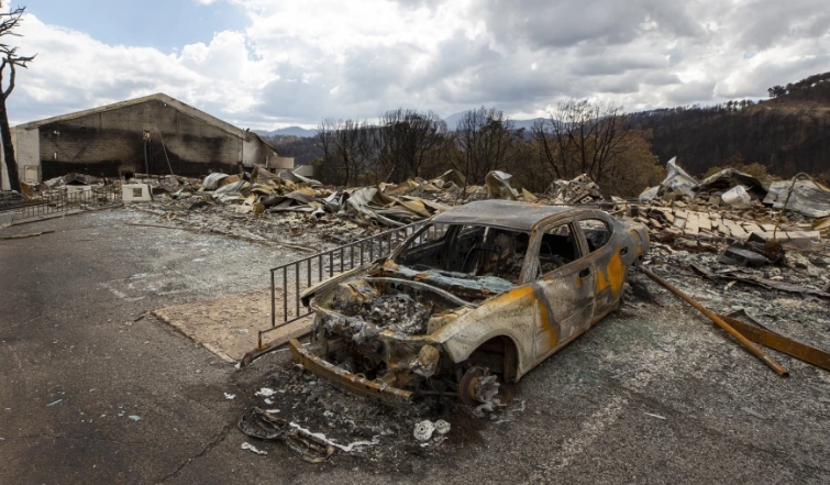 En la foto, un coche carbonizado y los restos del hotel Swiss Chalet tras ser destruido por el incendio de South Fork en Ruido | Foto: AP