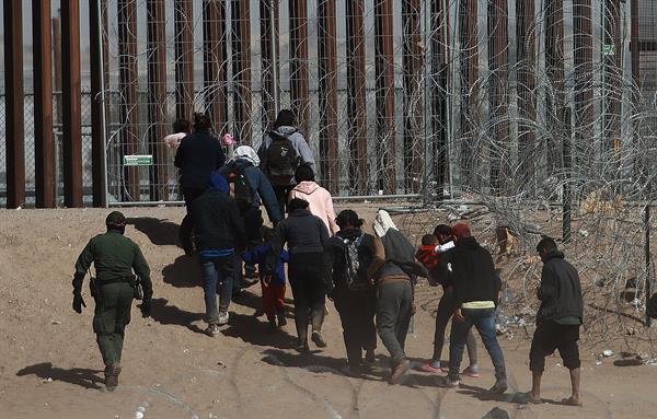 Migrantes caminando hacia la frontera que divide a México de los Estados Unidos