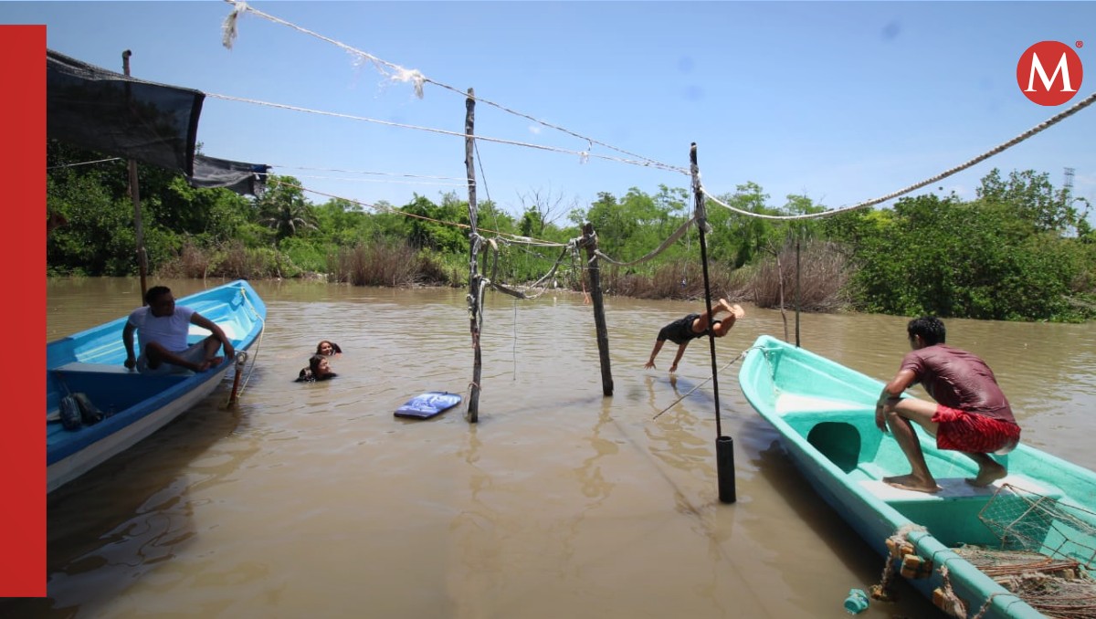 Jóvenes aprovechan la creciente del agua de los canales que conectan al río Pánuco para refrescarse. (Yazmín Sánchez)