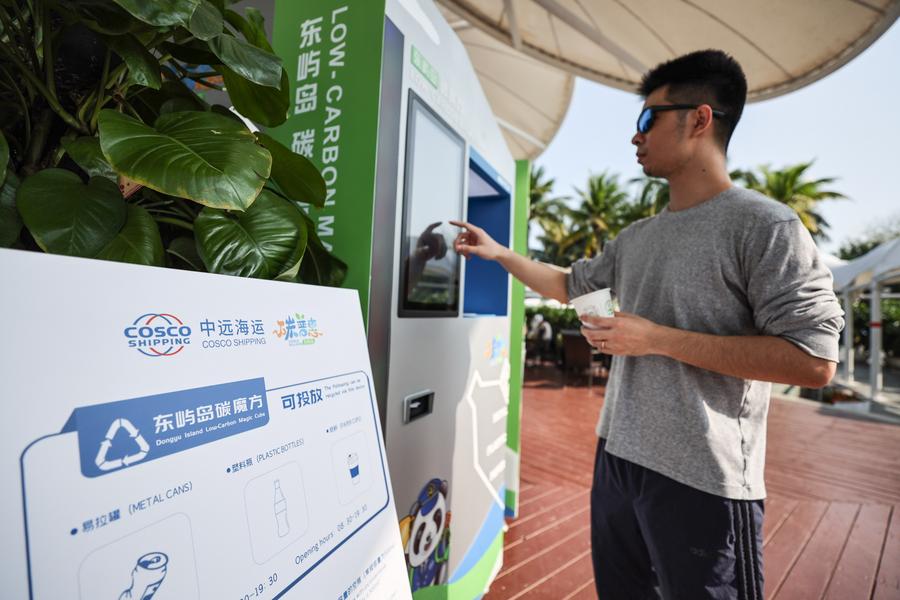 Un visitante prueba equipos de reciclaje en una zona de bajas emisiones de carbono. (Xinhua/ Zhang Liyun)