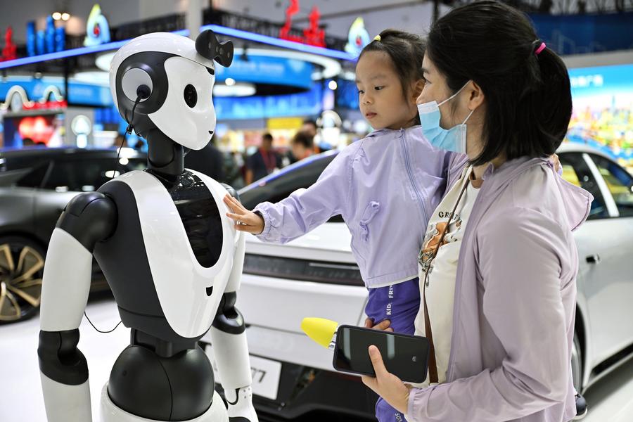 Niña interactúa con un robot activado por inteligencia artificial. (Xinhua/ Guo Cheng)