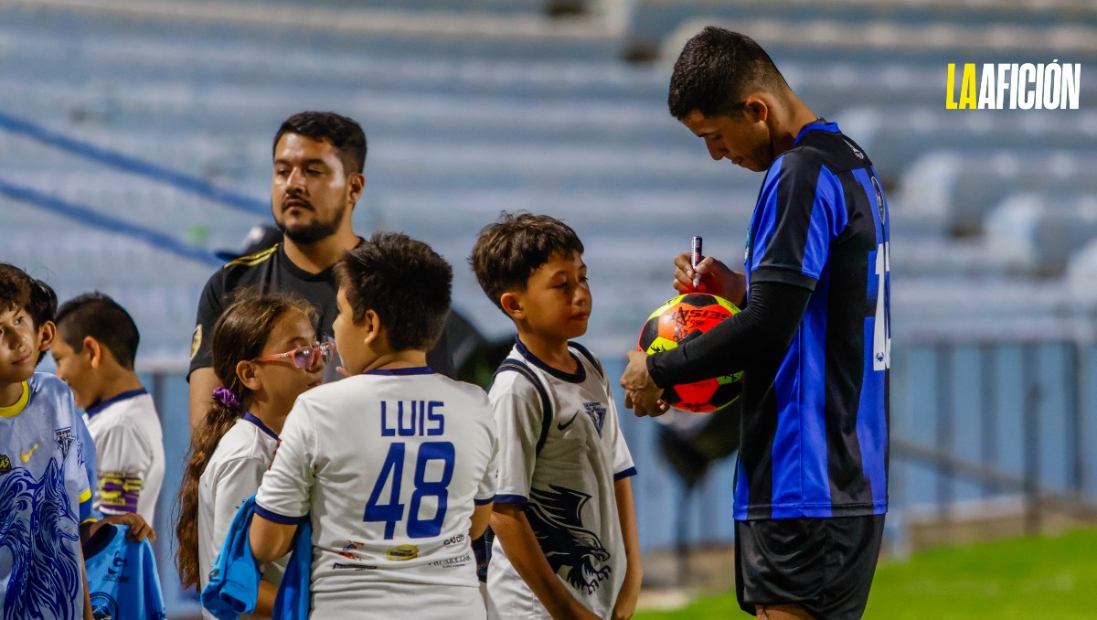 Jugadores del Tampico-Madero autografían balones a niños de escuela infantil.