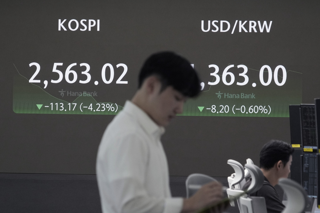 n operador de divisas trabaja junto a una pantalla que muestra el Korea Composite Stock Price Index | AP