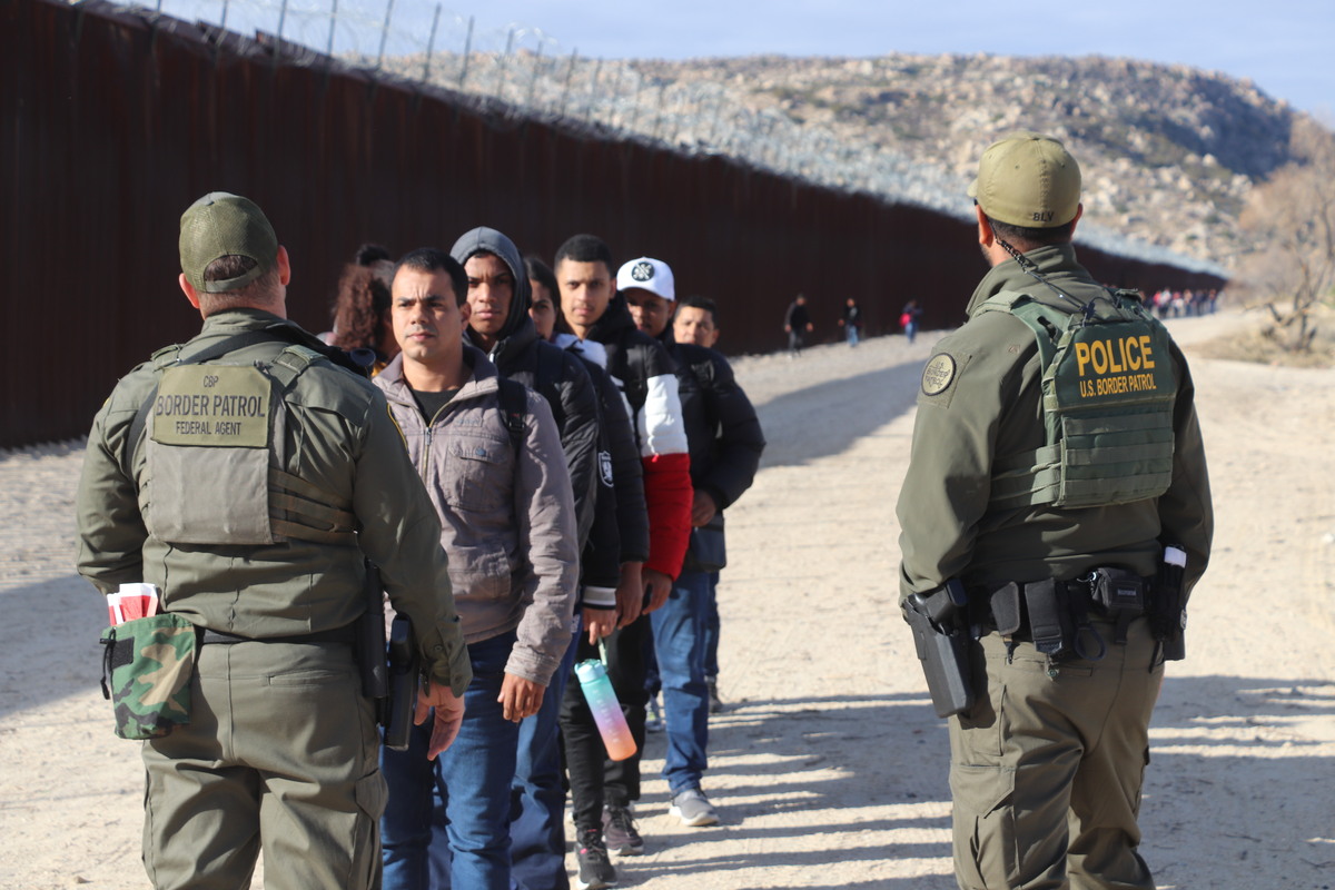 Agentes de CBP One aplica una revisión a migrantes. | EFE