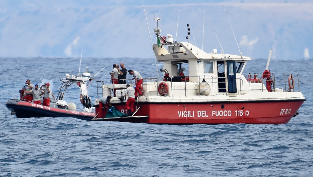 Buzos de los bomberos italianos llevan hasta un barco la bolsa con los restos mortales de una de las víctimas del naufragio del yate Bayesian | AP