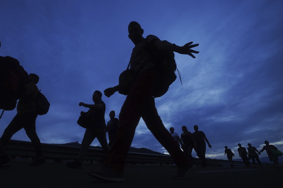Migrantes caminan por la carretera hacia la salida a Huixtla, Chiapas. | AP