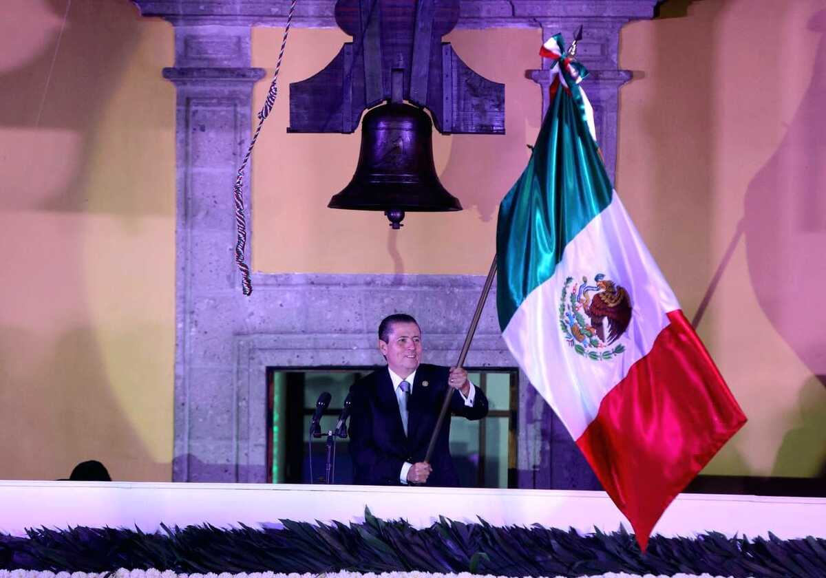 El alcalde Giovani Gutiérrez Aguilar ondea la bandera durante el Grito de Independencia en Coyoacán.