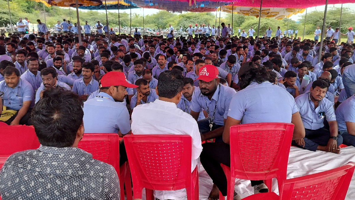 Trabajadores de una instalación de Samsung hablan con su líder sindical E. Muthukumar en huelga para exigir salarios más altos. Foto: (Reuters)